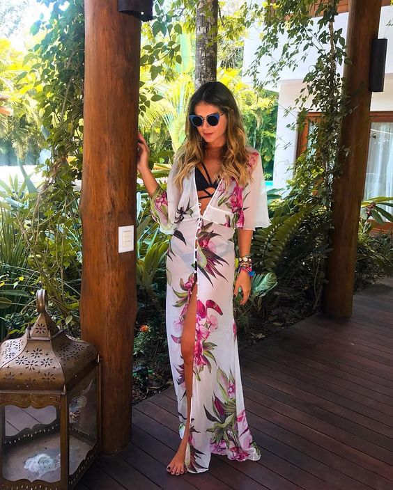 a black strappy bikini and a white long floral kimono contrast with each other and look very bold