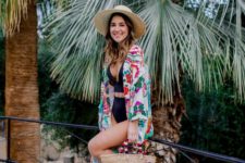 a colorful floral beach kimono paired with a black one piece make up a chic beach look