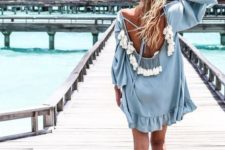 a powder blue tunic with bell sleeves, a cutout back with lacing and multiple tassels