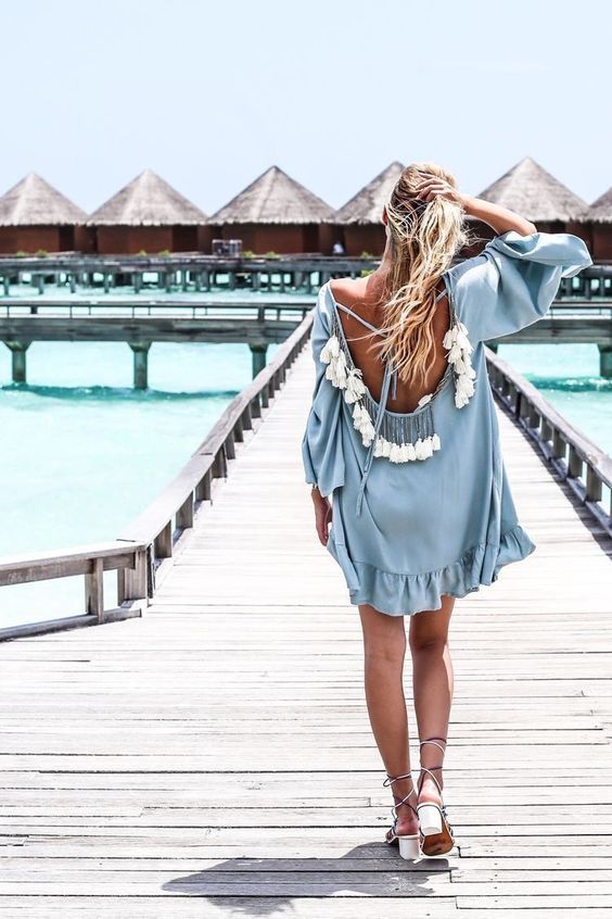 a powder blue tunic with bell sleeves, a cutout back with lacing and multiple tassels