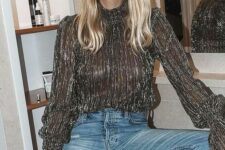 a black sparkling top with a turtleneck and blue jeans plus a red lip are a lovely and chic NYE look to rock