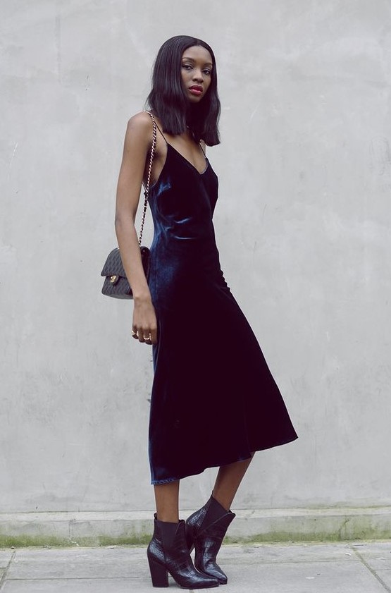 a navy velvet slip dress, black chelsea boots and a black clutch are a perfect combo for a NYE party