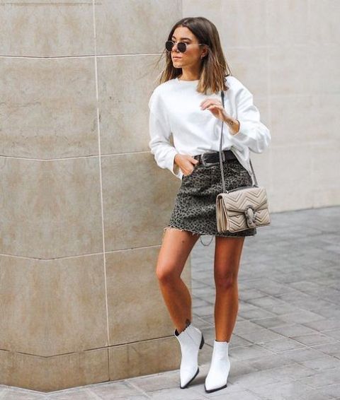a white sweatshirt, a leopard print mini, white booties, a neutral bag for a trendy spring look