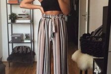 a black crop top, striped palazzo pants, red statement earrings for a bold and trendy look