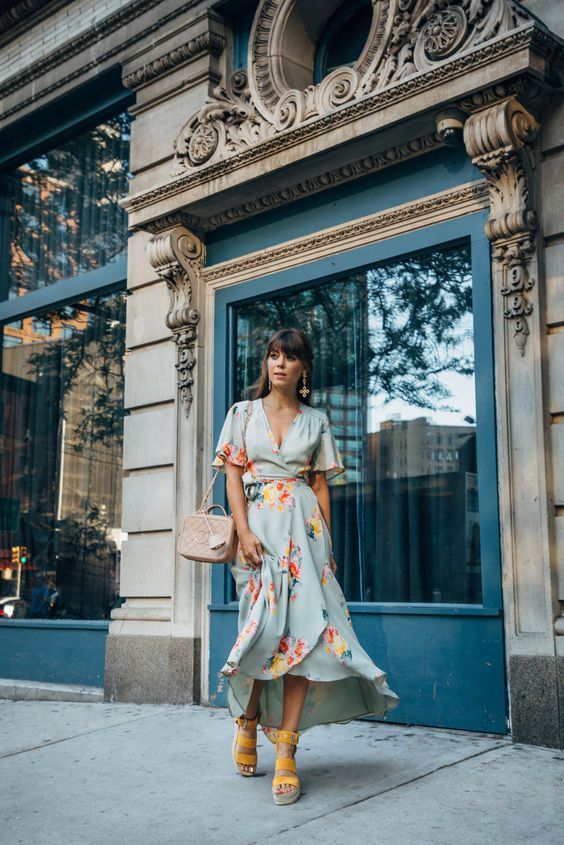 a blue floral wrap midi dress with short sleeves, yelloe platform shoes, a blush bag and statement earrings