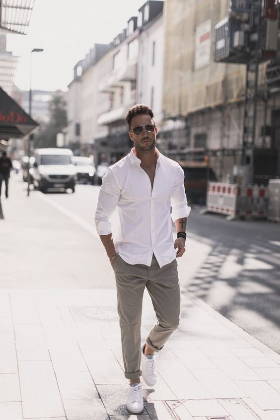 a casual summer work outfit with a white shirt with rolled up sleeves, grey rolled up pants, white sneakers