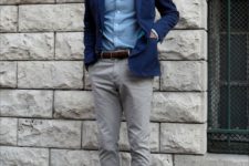 a casual work outfit with a blue shirt, a navy blazer, grey pants, brown loafers and a matching belt