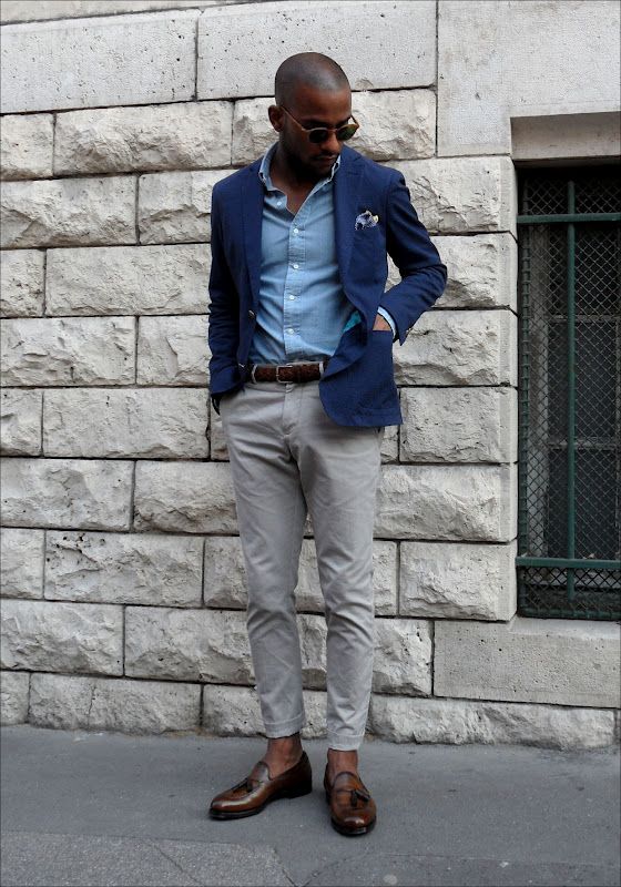 a casual work outfit with a blue shirt, a navy blazer, grey pants, brown loafers and a matching belt