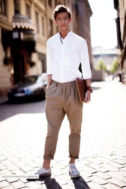 a casual work outfit with a white button down, tan pants, white sneakers and a leather file