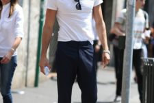 a relaxed summer work look with a white tee, navy pants, navy moccasins, a grey hat and sunglasses