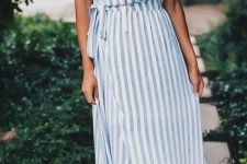 a blue and white wrap striped maxi dress with spaghetti straps, tan shoes and a pearl necklace