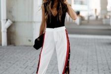 a party look with a black top, white side stripe pants, black shoes and a black bag