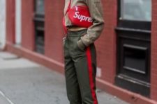 a sport outfit with a green crop hoodie, green side stripe pants, white trainers and a red bag