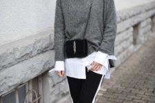 a stylish outfit with an oversized white shirt, a grey cashmere sweater, black side stripe pants, white sneakers and a crossbody bag