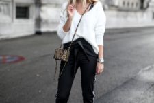 a white fluffy sweater, black side stripe pants, black star print Oxfords and a small snake skin bag