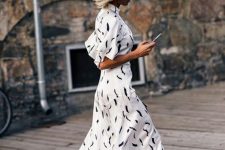 a white printed maxi A-line dress with short sleeves and white trainers for a chic look