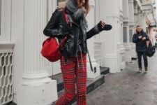 a black sweater, red plaid pants, black boots, a black leather jacket, a gey scarf and a red backpack for a comfy look