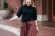 a black sweater with a turtleneck and short sleeves, a plaid A-line maxi skirt and a black bag