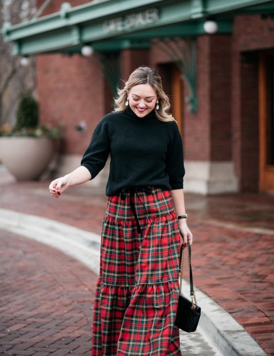 a black sweater with a turtleneck and short sleeves, a plaid A-line maxi skirt and a black bag