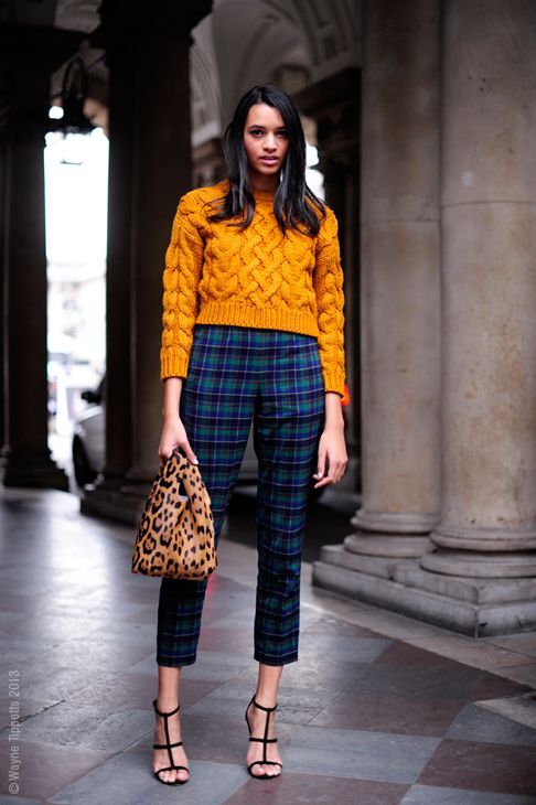 a bold Christmas look with a mustard cropped sweater, navy plaid cropped pants, black shoes and a leopard bag