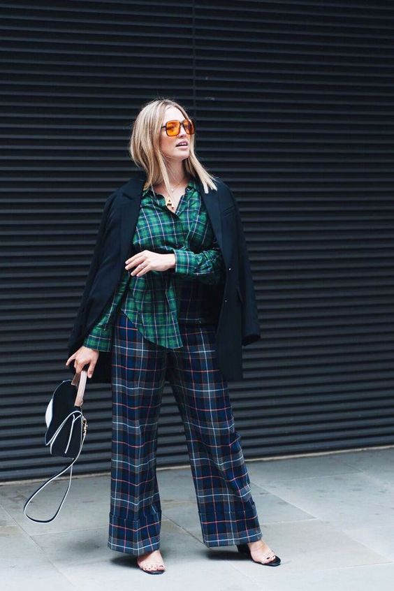 a bold Christmas outfit with a green plaid shirt, navy plaid trousers, a black blazer, sheer shoes and a bag
