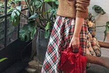a brown sweater, a bold plaid pleated midi, vintage brown shoes and a red bag for pulling off a vintage holiday look