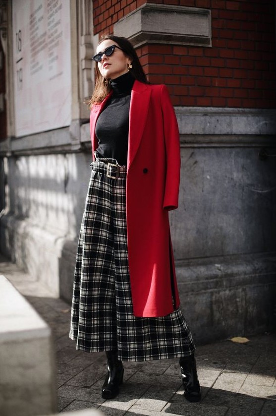 a chic outfit with a black turtleneck, plaid culottes, black shoes and a red coat is style and classics