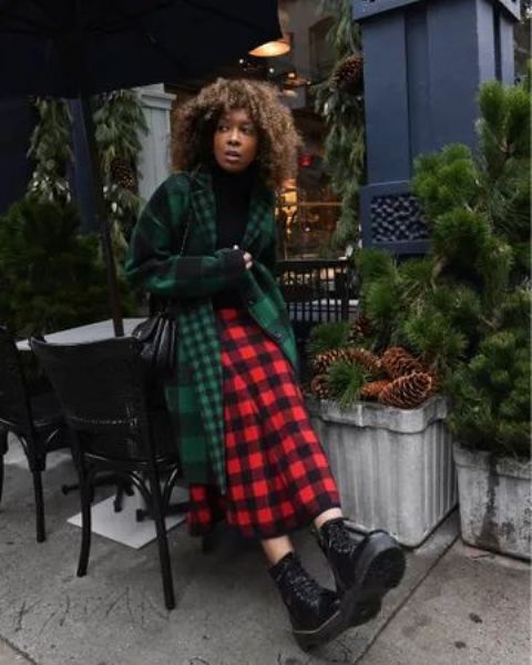 a cool plaid Christmas outfit with a black turtleneck, a red and black plaid midi, a grene plaid coat, combat boots and a black bag
