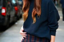 a navy oversized sweater, a dark plaid mini skirt and a gold watch for a chic and simple look