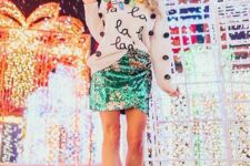 a white pompom sweatshirt with prints, an emerald sequin mini, dusty pink booties for a fun Christmassy look