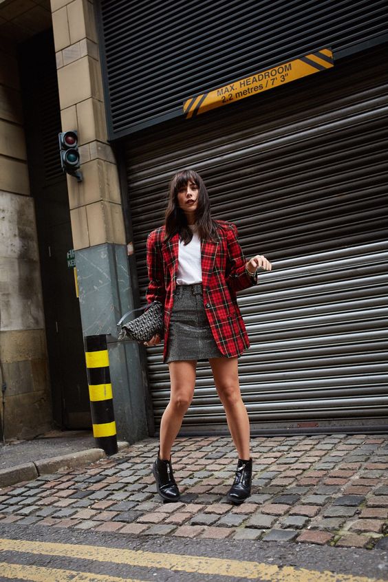 a white t-shirt, a grey skirt, black boots, a red plaid blaer and a woven bag are a lovely look for Christmas