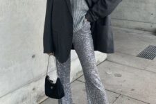 an oversized grey sweater, silver sequin flare pants, a black blazer and a small black bag for a modern holiday look
