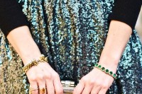 a black turtleneck, a green sequin midi skirt, a gold clutch and gorgeous bracelets for a chic Christmas party look