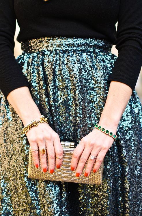 a black turtleneck, a green sequin midi skirt, a gold clutch and gorgeous bracelets for a chic Christmas party look
