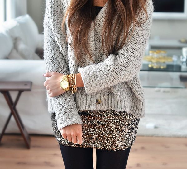 a casual Christmas outfit with a black top, a grey cardigan, a silver sequin mini skirt and black tights