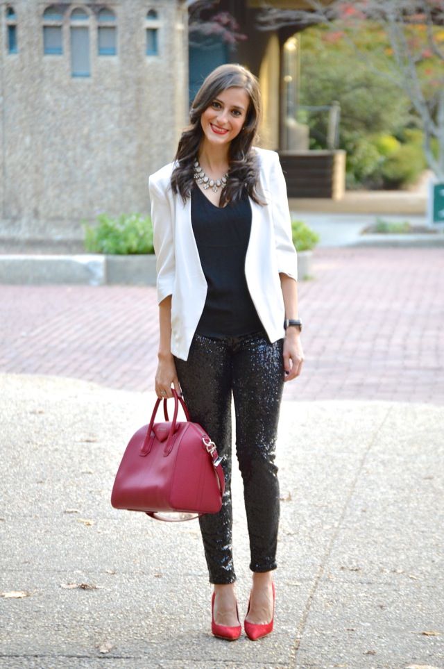 a holiday outfit with a black top and black sequin pants, red shoes, a white blazer and a red bag