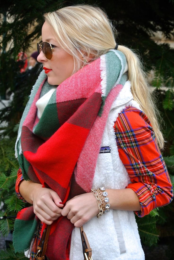 a red plaid shirt, a white faux fur vest and an oversized red, green and white plaid scarf as an accent for the holidays
