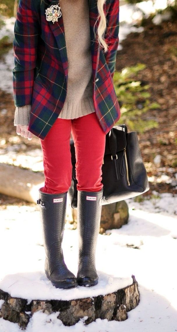 a cool Christmas outfit with a grey jumper, red jeans, rubber boots, a bold plaid blazer, a black bag is all cool