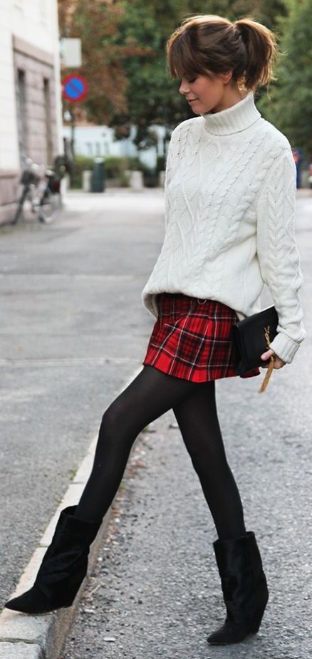 a catchy holiday look with a white oversized sweater, a red plaid mini, black tights and boots and a black clutch is suitable for a party