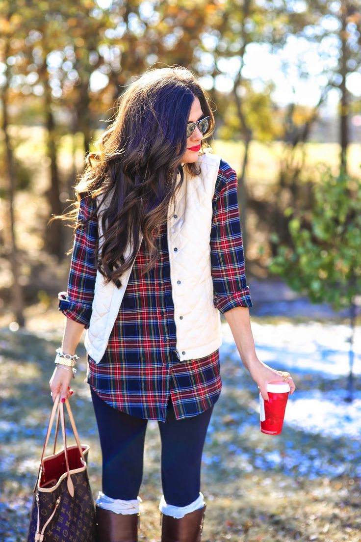 a relaxed Christmas outfit with a dark plaid shirt, navy skinnies, a white quilted vest, rubber boots and a large tote