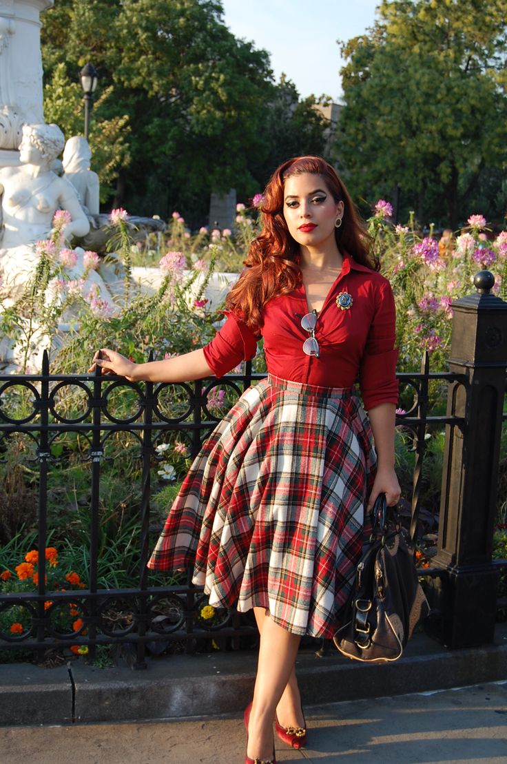a retro glam Christmas look with a red shirt, a plaid pleated midi skirt, red shoes and a large bag plus a pin up makeup