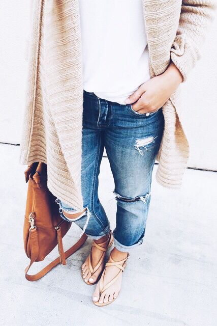 blue ripped straight jeans, a white top, nude strappy sandals, a neutrla cardigan and a brown bag