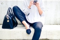 a monochromatic outfit with black skinny pants, an oversized grey top, black flats and a black bag