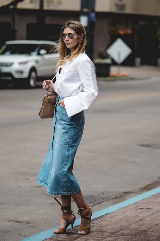 a chic outfit with a blue denim midi, a white shirt, brown strap up shoes and a brown bag