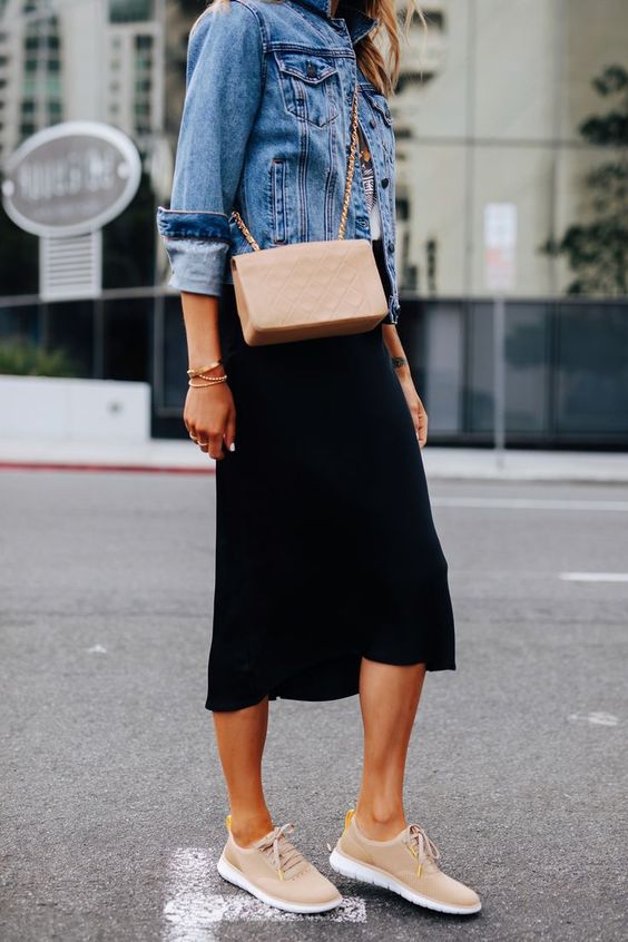 a tee, a blue denim jacket, a black midi skirt, tan sneakers and a blush crossbody for spring
