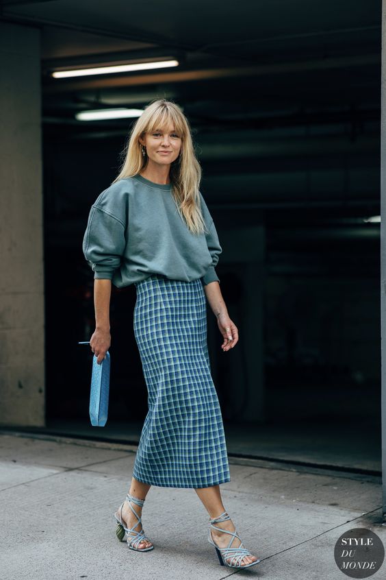 an oversized grey sweatshirt, a blue checked midi skirt, blue strappy heels and a blue clutch