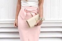 a sexy outfit with a white turtleneck sleeveless top, a pink pencil midi with a bow, a nude clutch and blush spiked shoes
