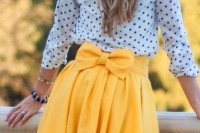 a simple spring outfit with a polka dot shirt and a sunny yellow pleated A-line skirt with a bow on the back