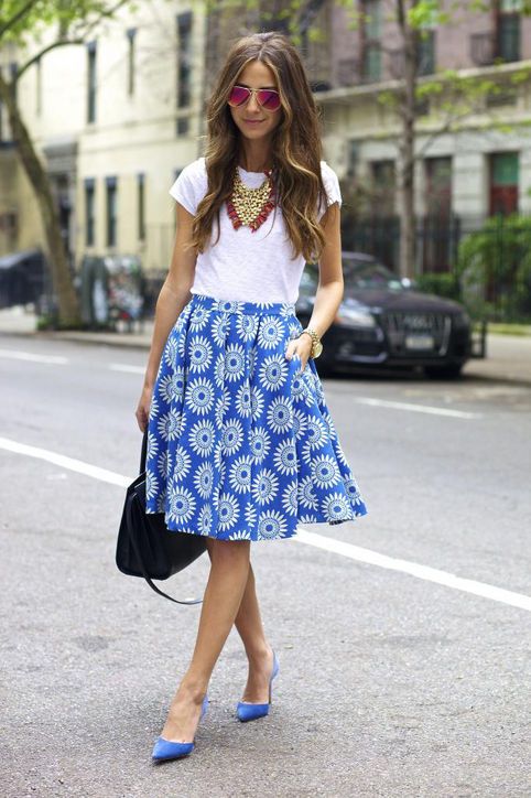 a bold outfit with a white tee, a blue printed A-line skirt, blue shoes and statement necklaces for summer