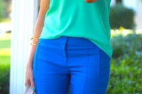 a colorful look with a green top, bright blue pants, statement necklaces and a neutral bag that matches